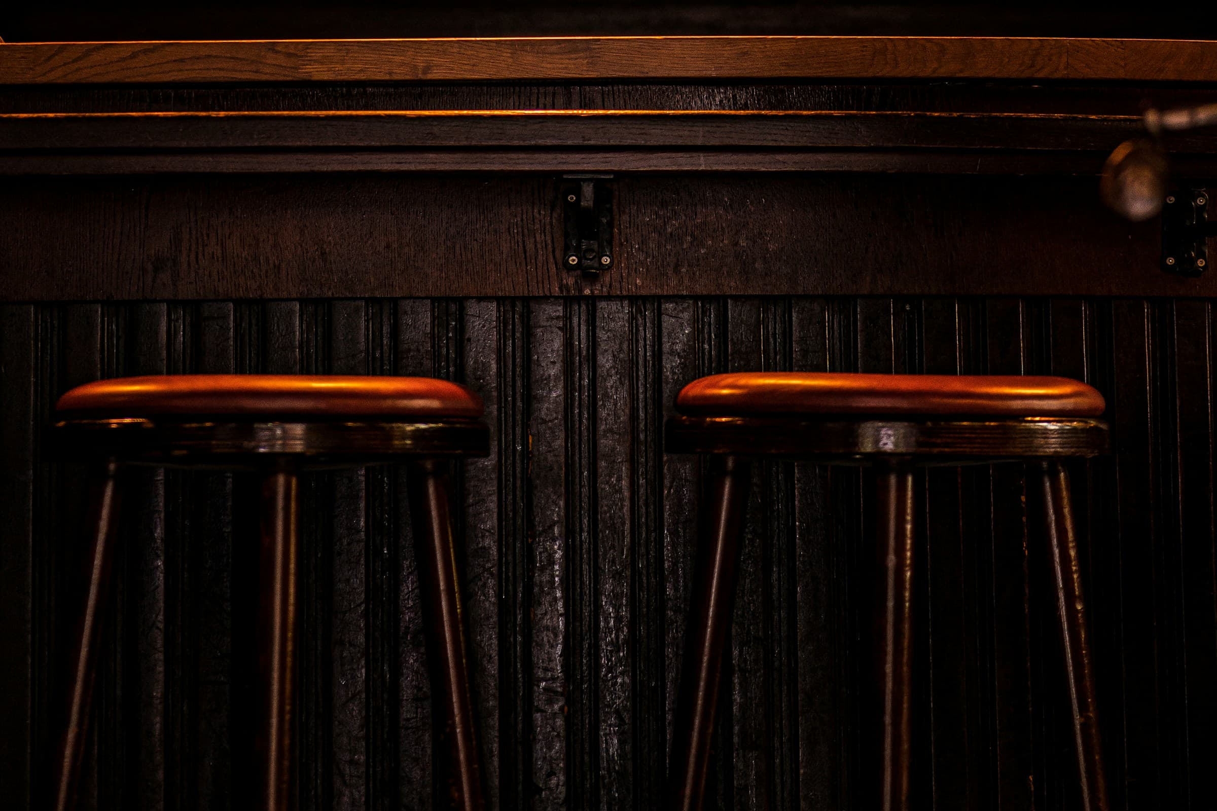The full length of the counter with twenty stools and the tin ceiling